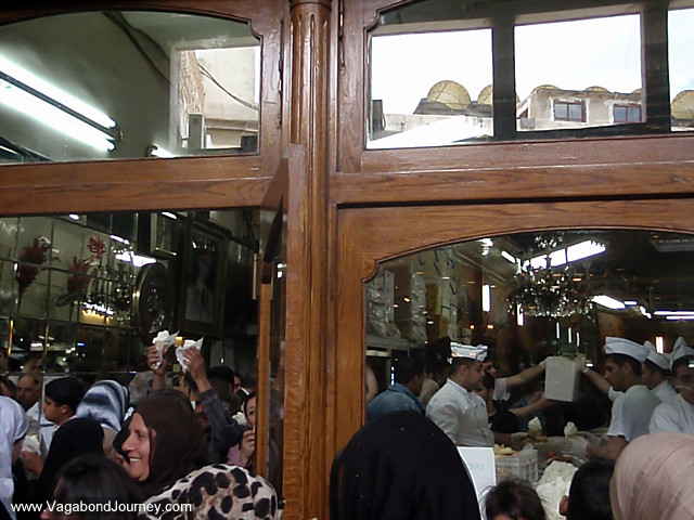 crowds buy ice cream in a souq in syria