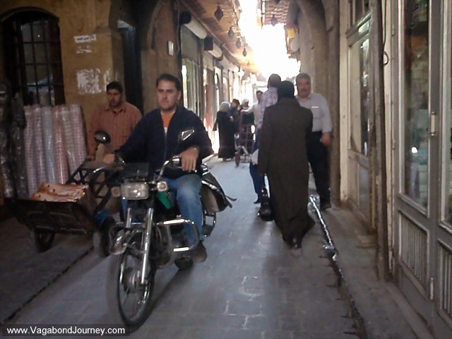 man motorbike aleppo, syriaPeople and Souqs of Aleppo, Syriabr><br>
Man on a motorbike and men and women walk through narrow streets of the old city 
Aleppo, Syria.<br><br>
<img src=