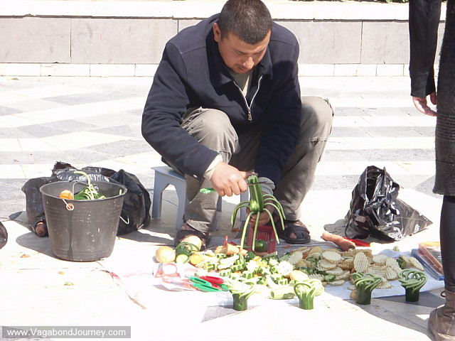man demonstrating vegetable peelers on cucumber flowers